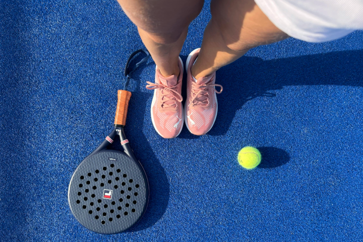 A beginner padel player enjoying their first lesson on court at The Point Racket & Social Club