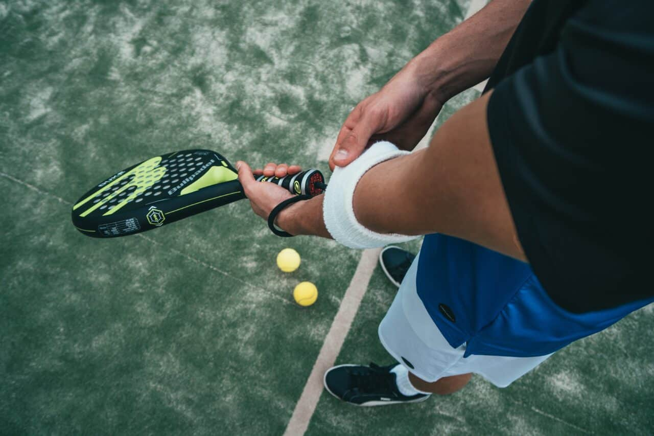 Two players on a padel court preparing for a match on a sunny day